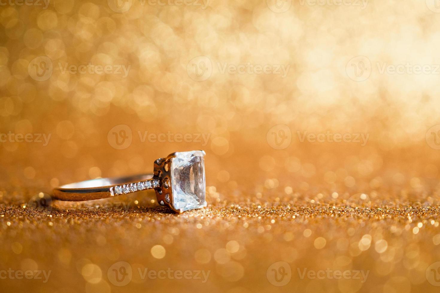Jewelry diamond ring with abstract festive glitter Christmas holiday texture background blur with bokeh light photo