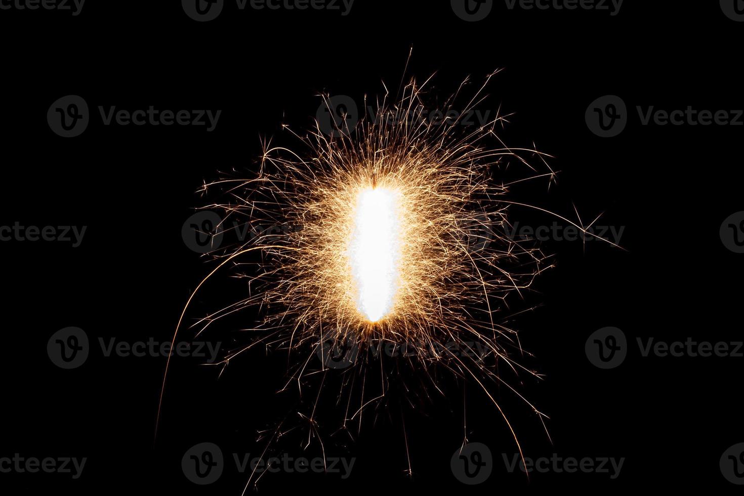 Burning sparkler isolated on black background. Fireworks theme. Light effect and texture. photo