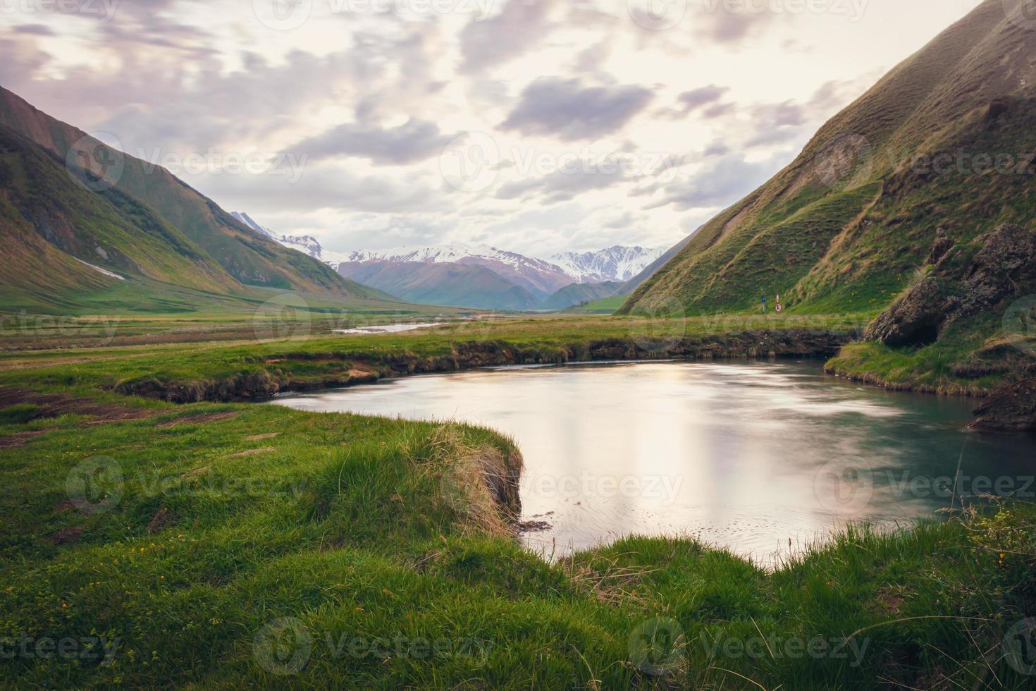mineral lake in Truso valley with green landscape and mountains in the background photo