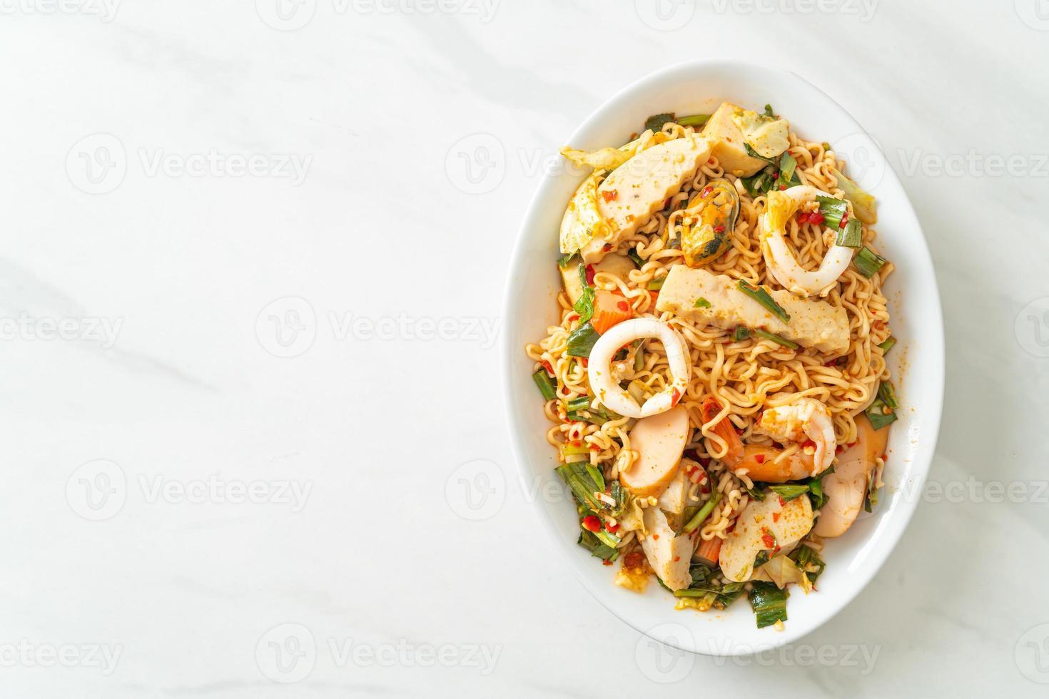 Ensalada picante de fideos instantáneos con carnes mixtas foto