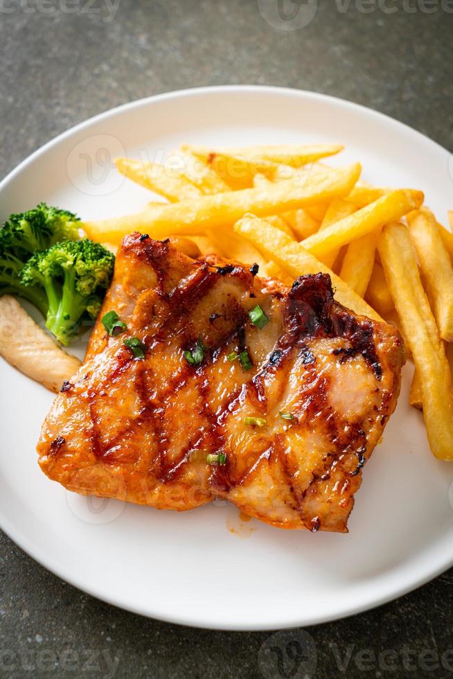 grilled chicken steak with potato chips or french fries photo