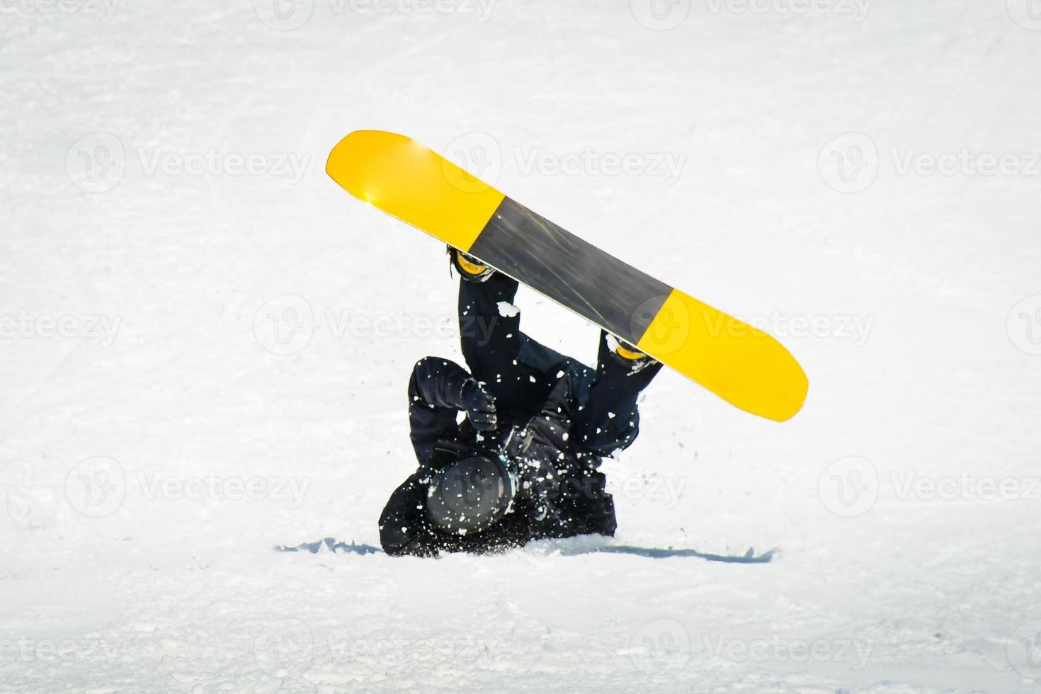 Male snowboarder on snowboard land on back in ski resort. Learning tricks and extreme ride downhill. Accidents on slopes in winter concept photo