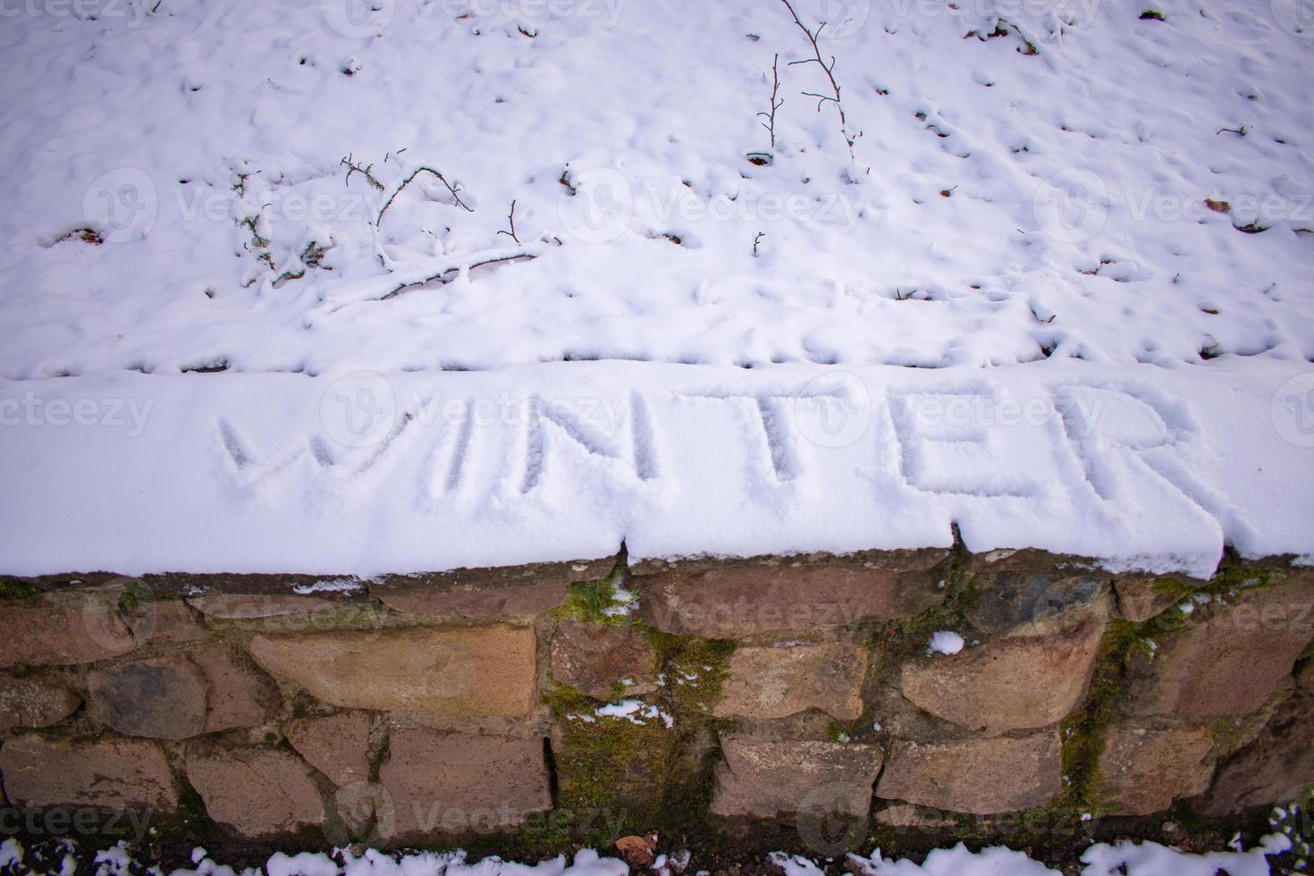 winter word written on the snow of the forest photo