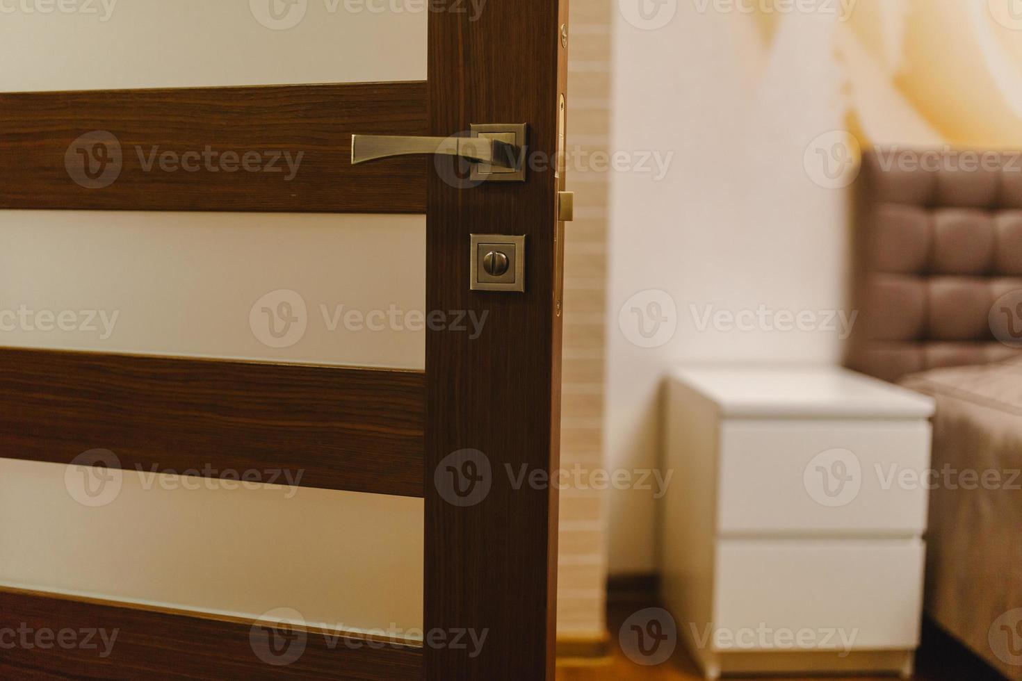 Keyhole and metal handle of a wooden door. brown wooden door with glass photo