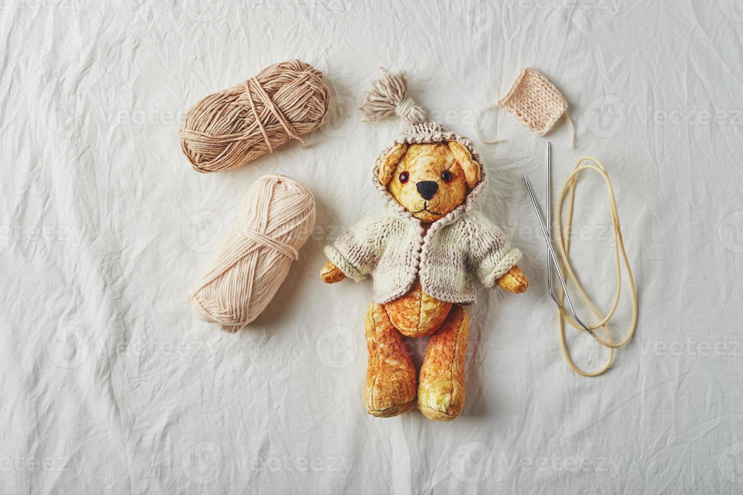 Handmade teddy bear and knitted little sweaters photo