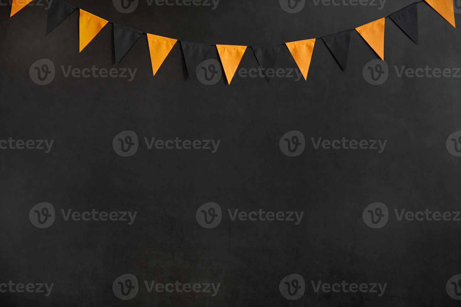 Halloween garland of black and orange flags on a dark background with space for text photo