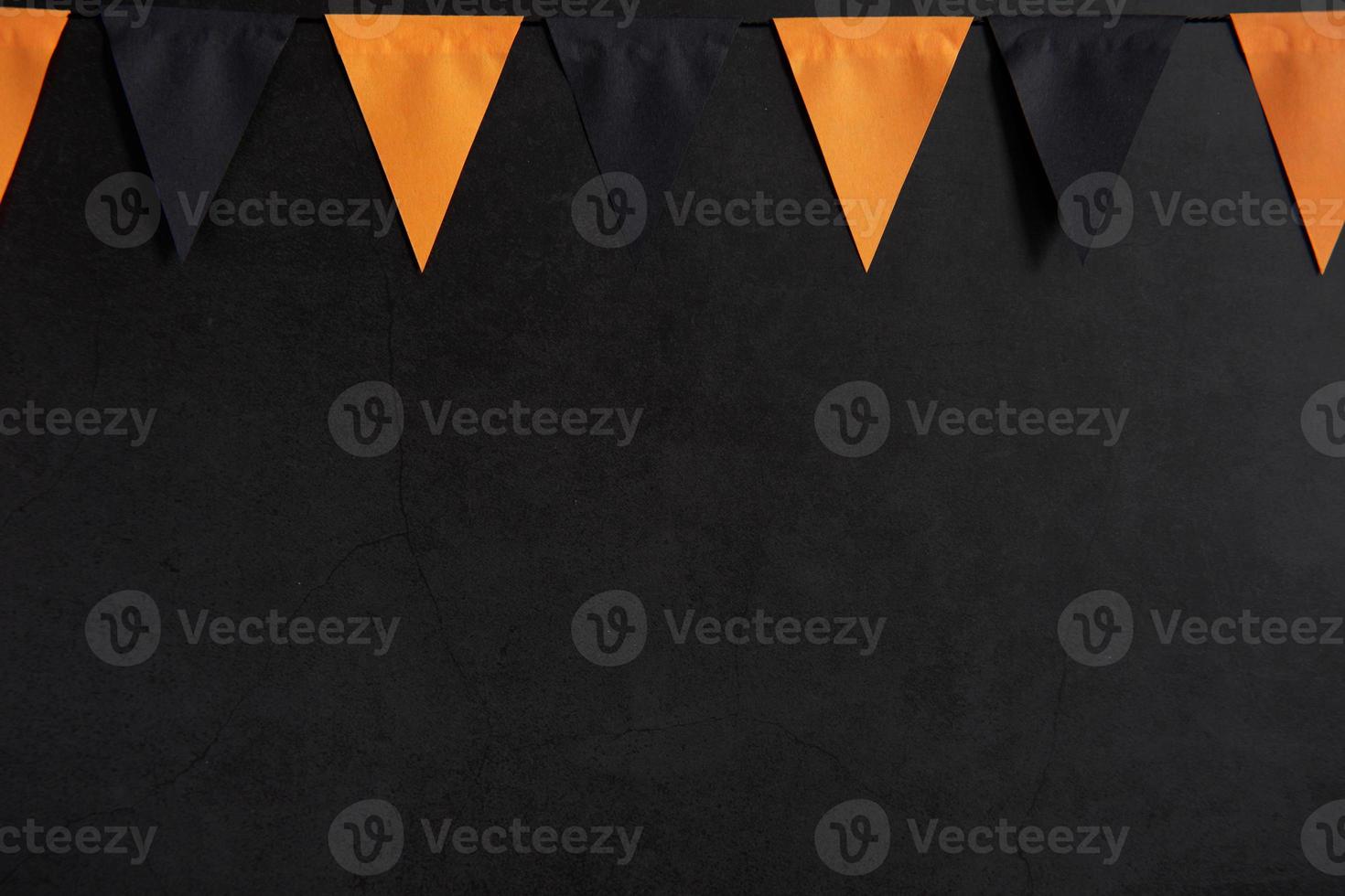 Halloween garland of black and orange flags on a dark background with space for text photo