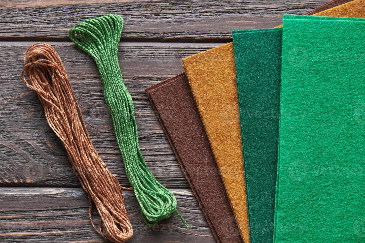 Materials for autumn crafts with children. Felt and threads on a wooden background photo