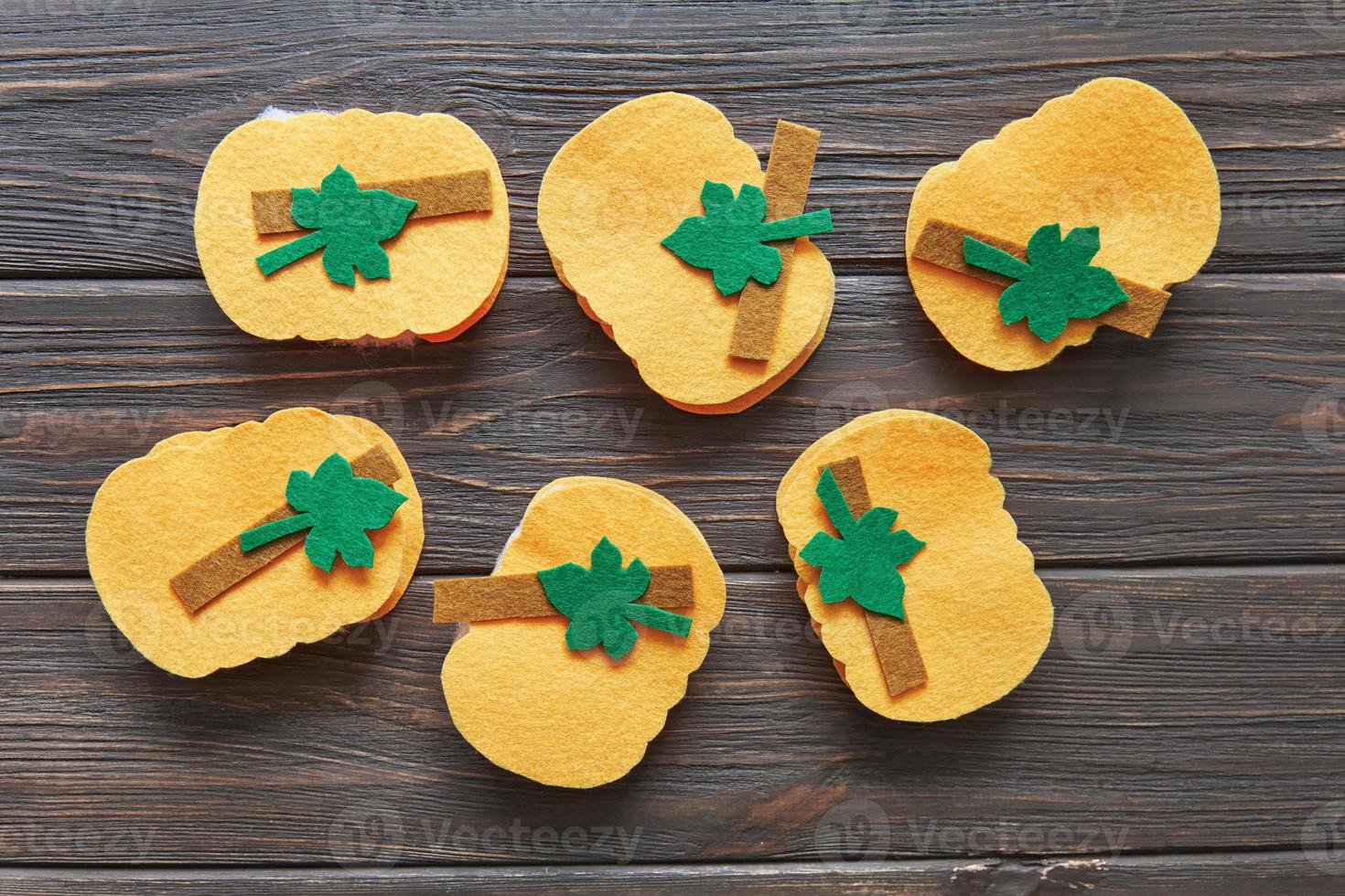 Step-by-step instructions for decorative crafts pumpkin made of felt for Halloween. Carved details of several pumpkins photo