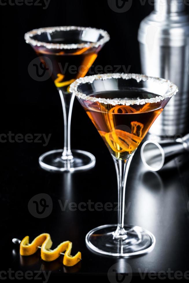 Martinis de cítricos de naranja sobre fondo negro foto