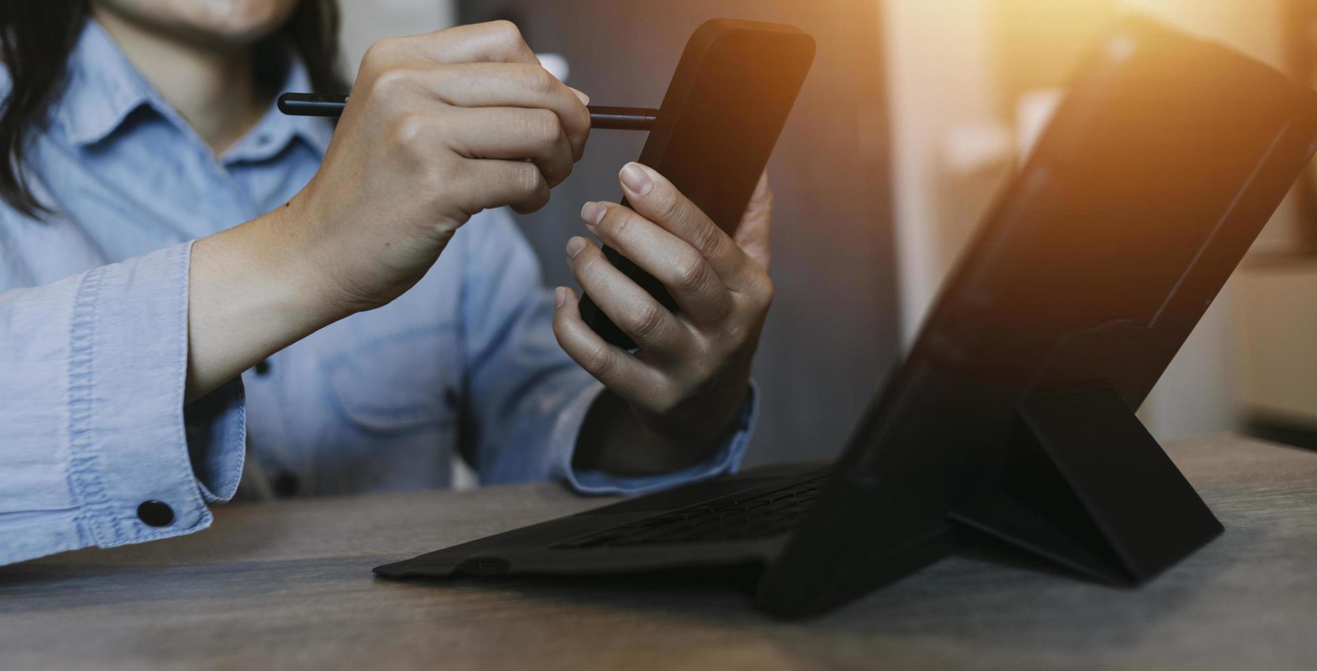 Businessman hands working with finances about cost and calculator and laptop with tablet, smartphone at office in morning light photo