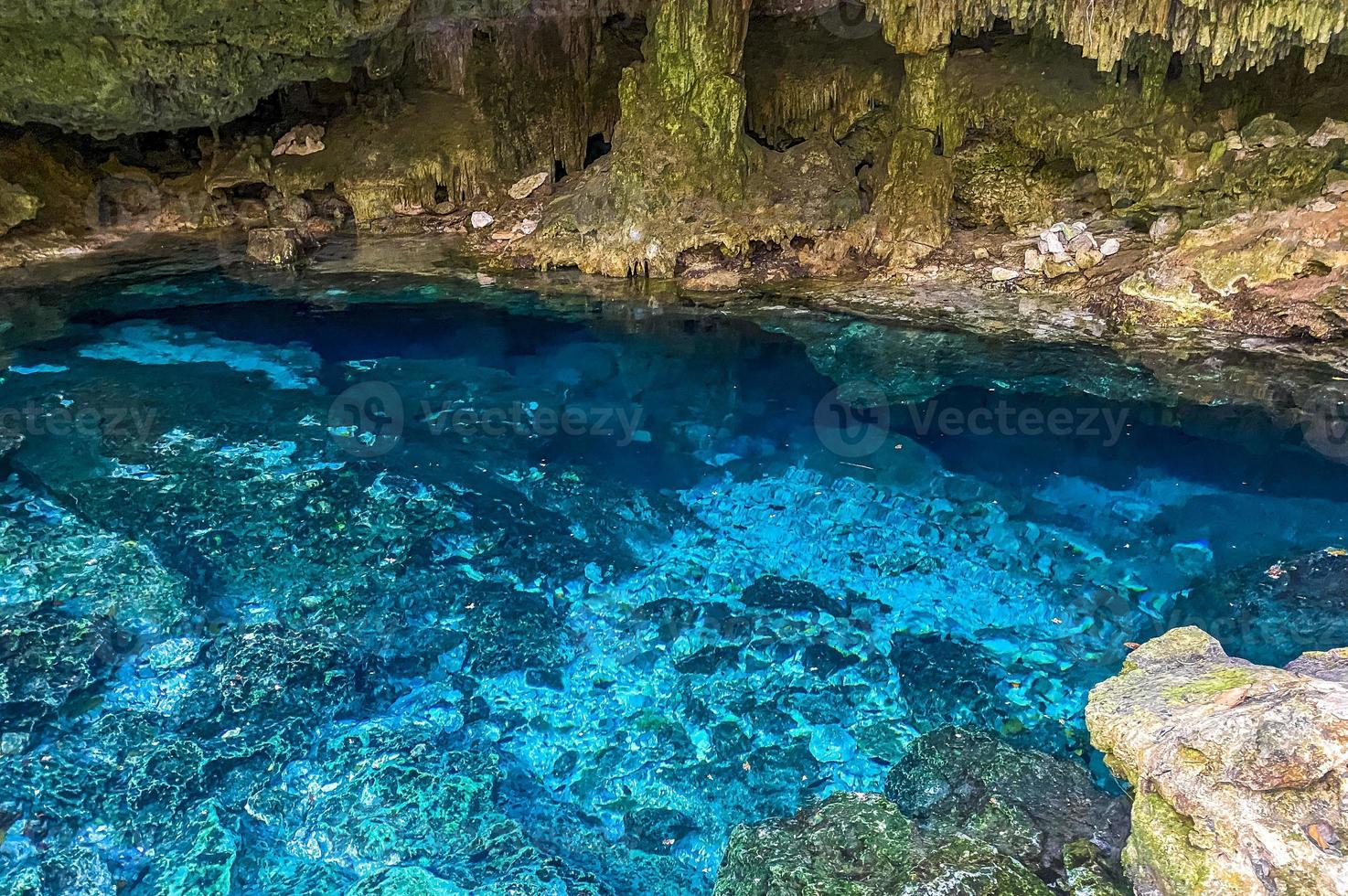 Blue turquoise water limestone cave sinkhole cenote Tajma ha Mexico. photo