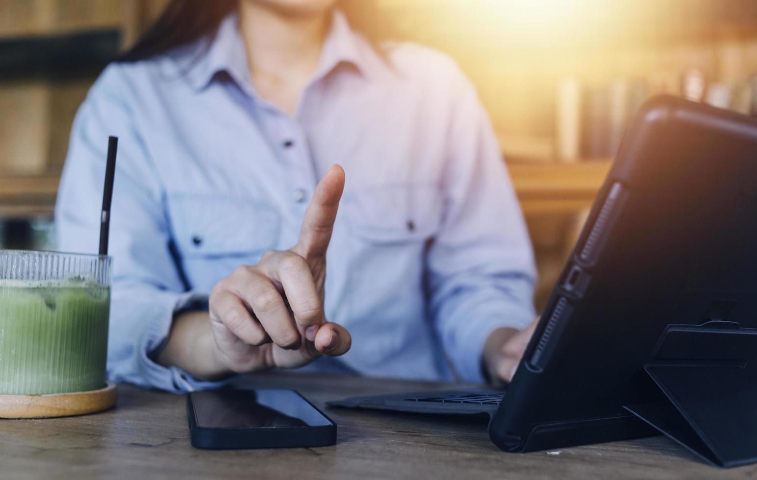 Businessman hands working with finances about cost and calculator and laptop with tablet, smartphone at office in morning light photo