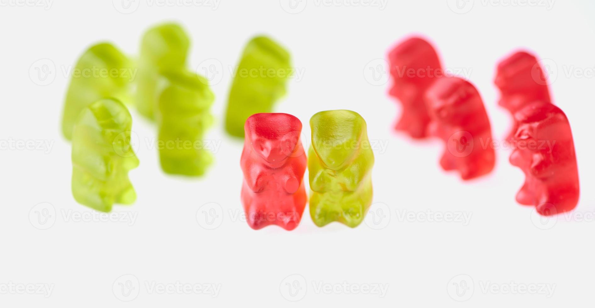 green gummy bears on the left and red gummy bears on the right side and one pair together photo