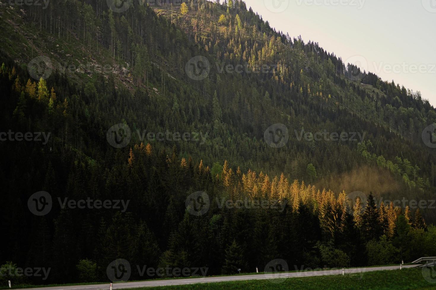 Sunset landscape high peaks and foggy valley under vibrant colorful evening sky in rocky mountains at Austria. photo