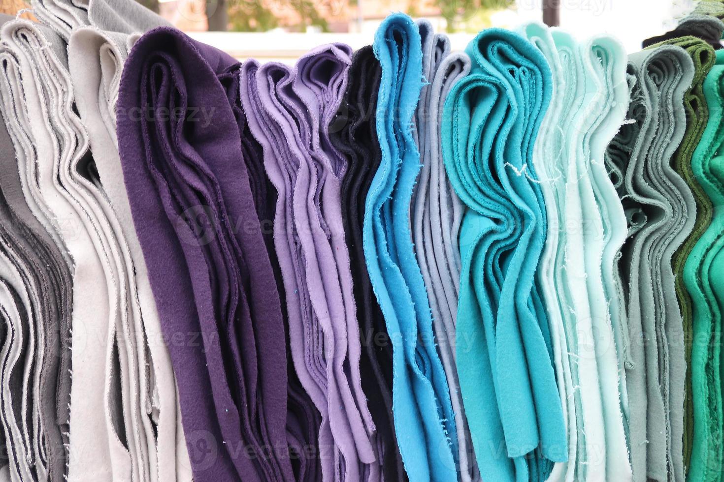 Detailed close up view on samples of cloth and fabrics in different colors found at a fabrics market photo