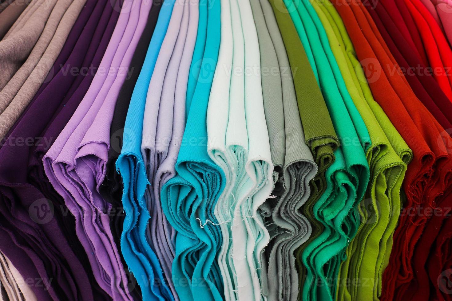 Detailed close up view on samples of cloth and fabrics in different colors found at a fabrics market photo