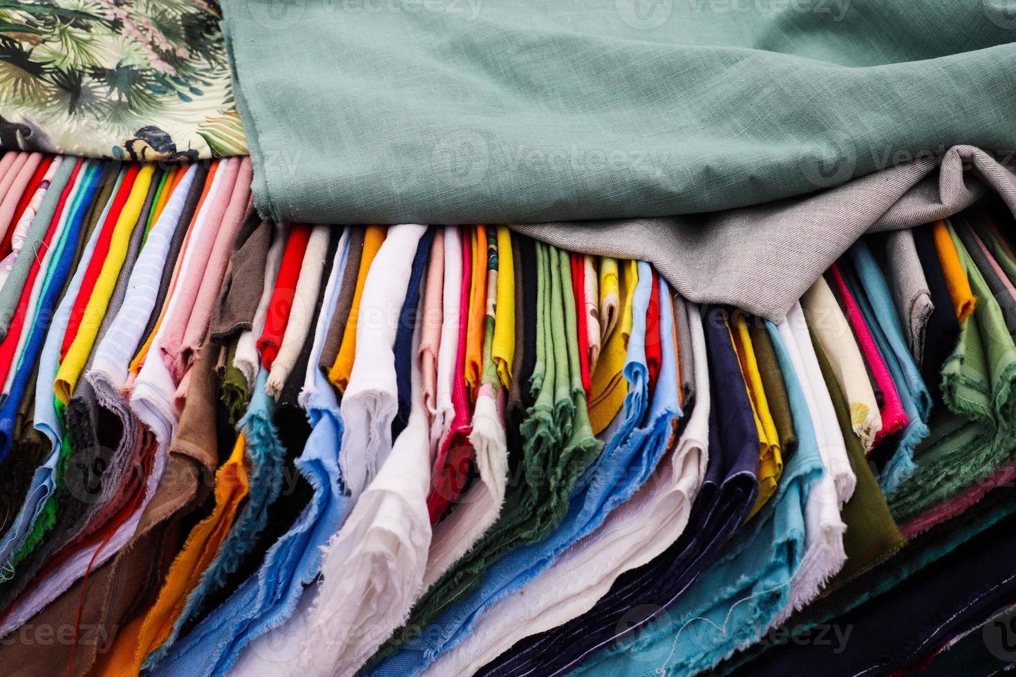 Detailed close up view on samples of cloth and fabrics in different colors found at a fabrics market photo