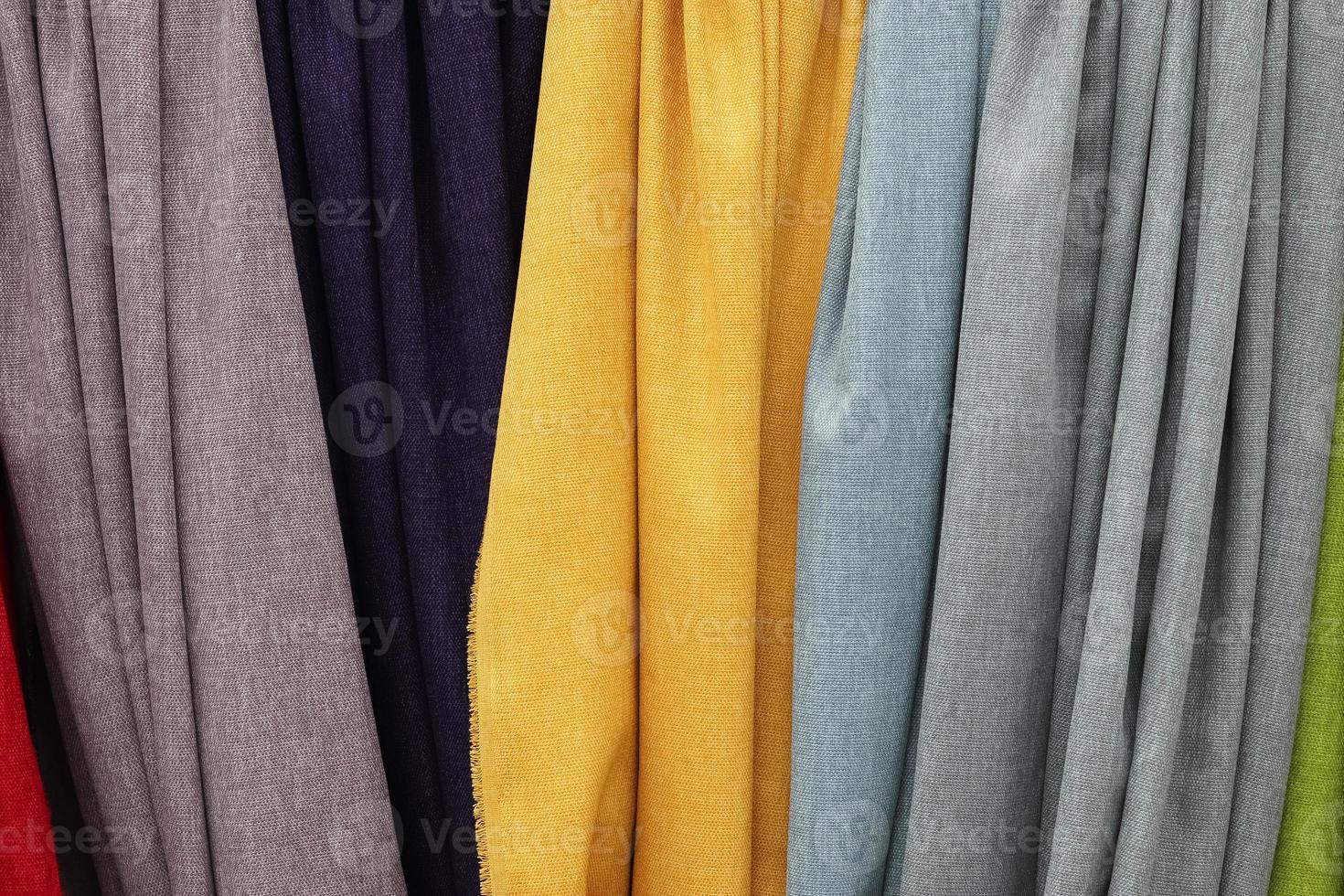 Detailed close up view on samples of cloth and fabrics in different colors found at a fabrics market photo