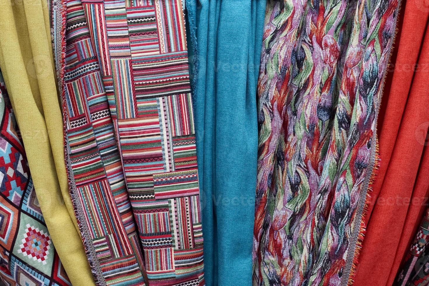 Detailed close up view on samples of cloth and fabrics in different colors found at a fabrics market photo