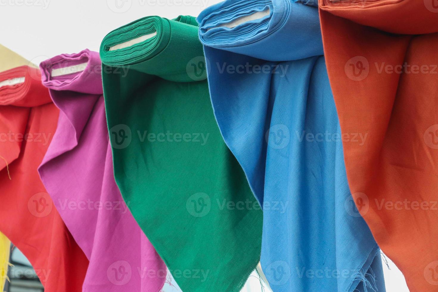 Detailed close up view on samples of cloth and fabrics in different colors found at a fabrics market photo
