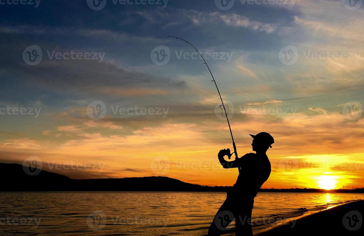 Young Man Fishing at Sunset photo