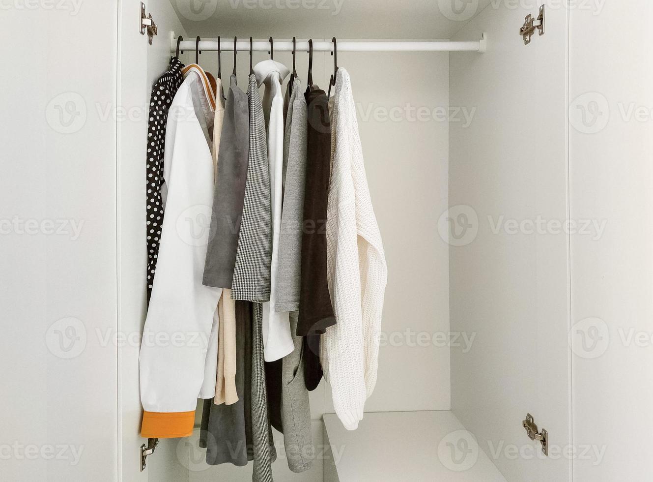 Wardrobe with basic clothes in room scandi interior. photo