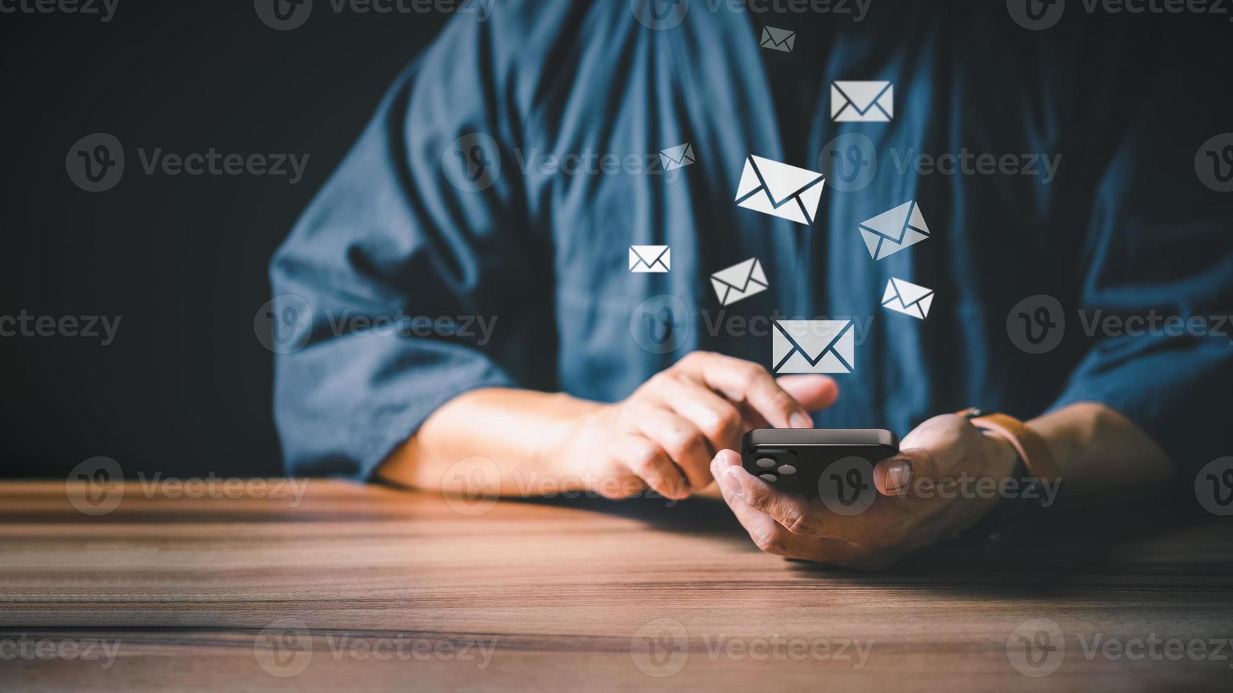 Man's hand sending message from mobile phone with e-mail icon, Email marketing and newsletter concept. photo