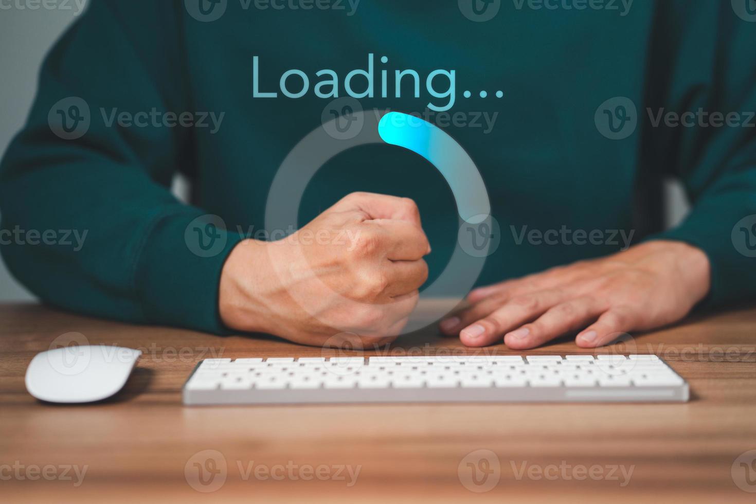 Man using a computer keyboard to download and waiting to loading digital business data form website, concept of waiting for load of loading bar. photo