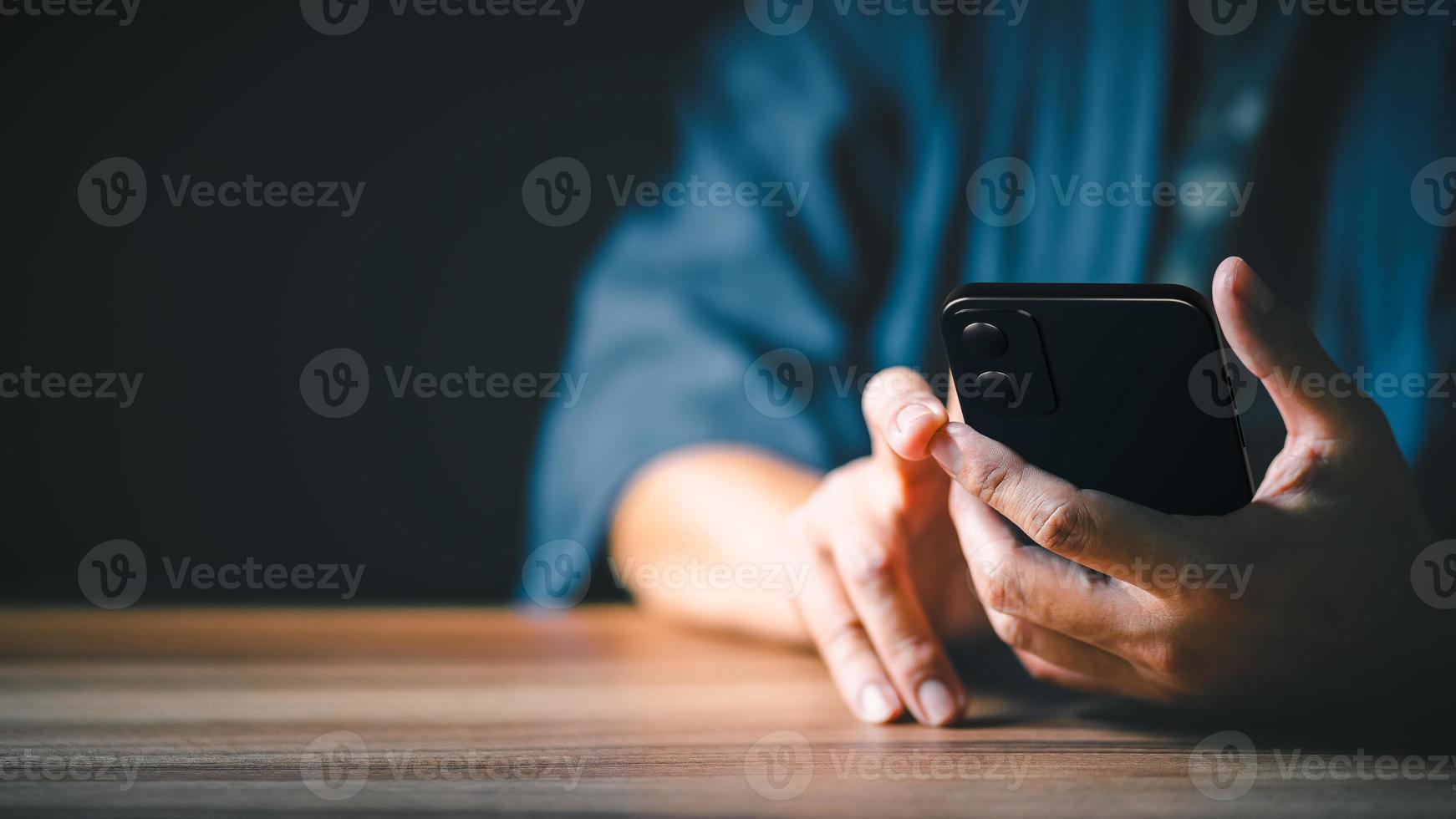 Closeup image of a man holding and using mobile phone or smartphone. photo