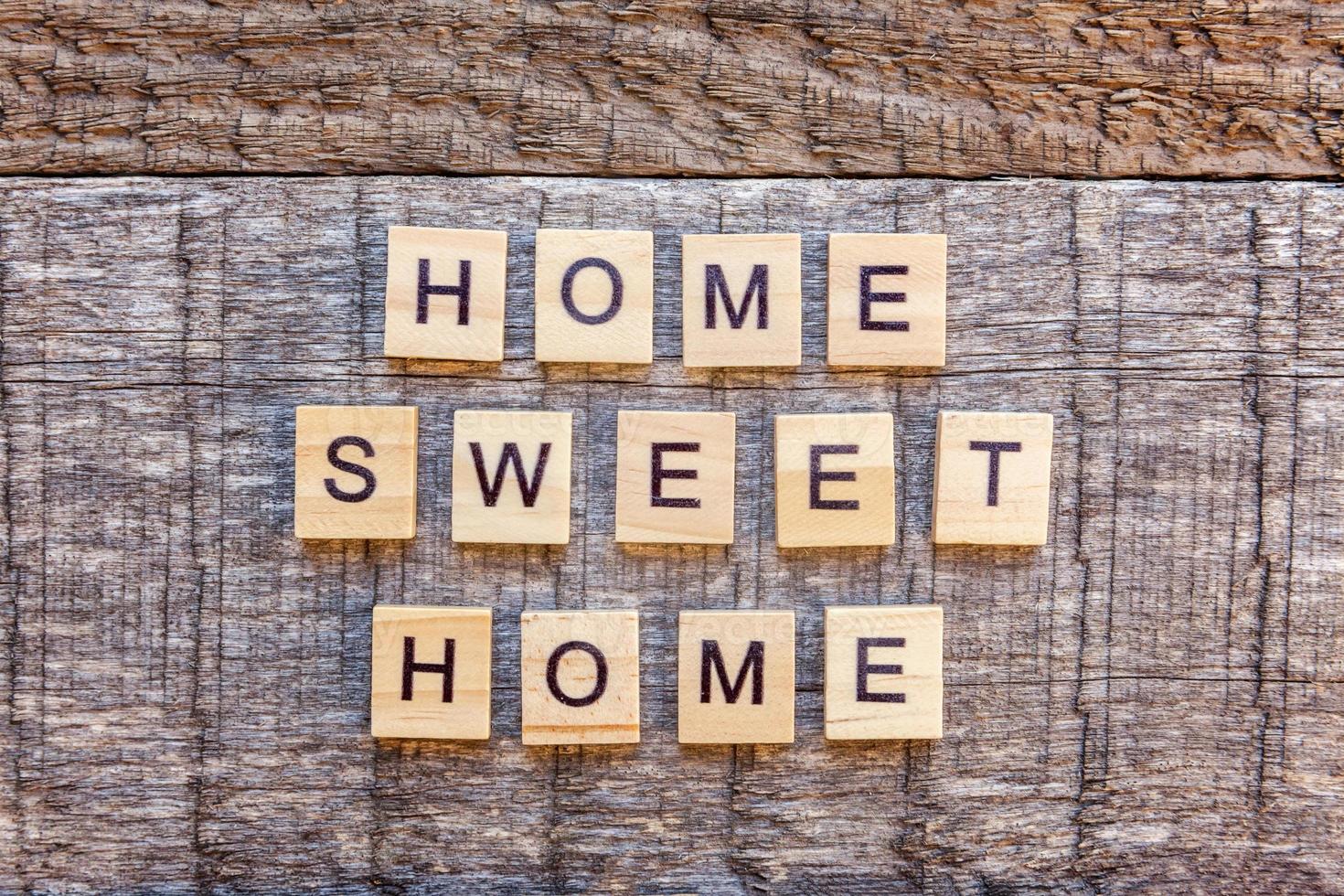 Inscription HOME SWEET HOME letters word on wooden background photo