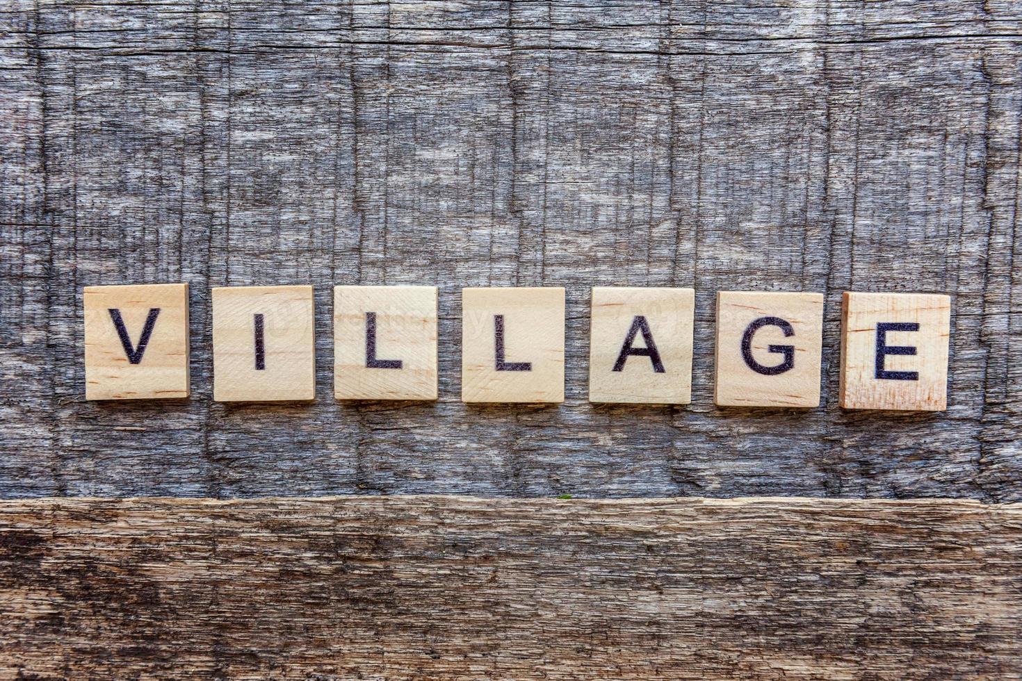 Inscription VILLAGE letters word on wooden background photo