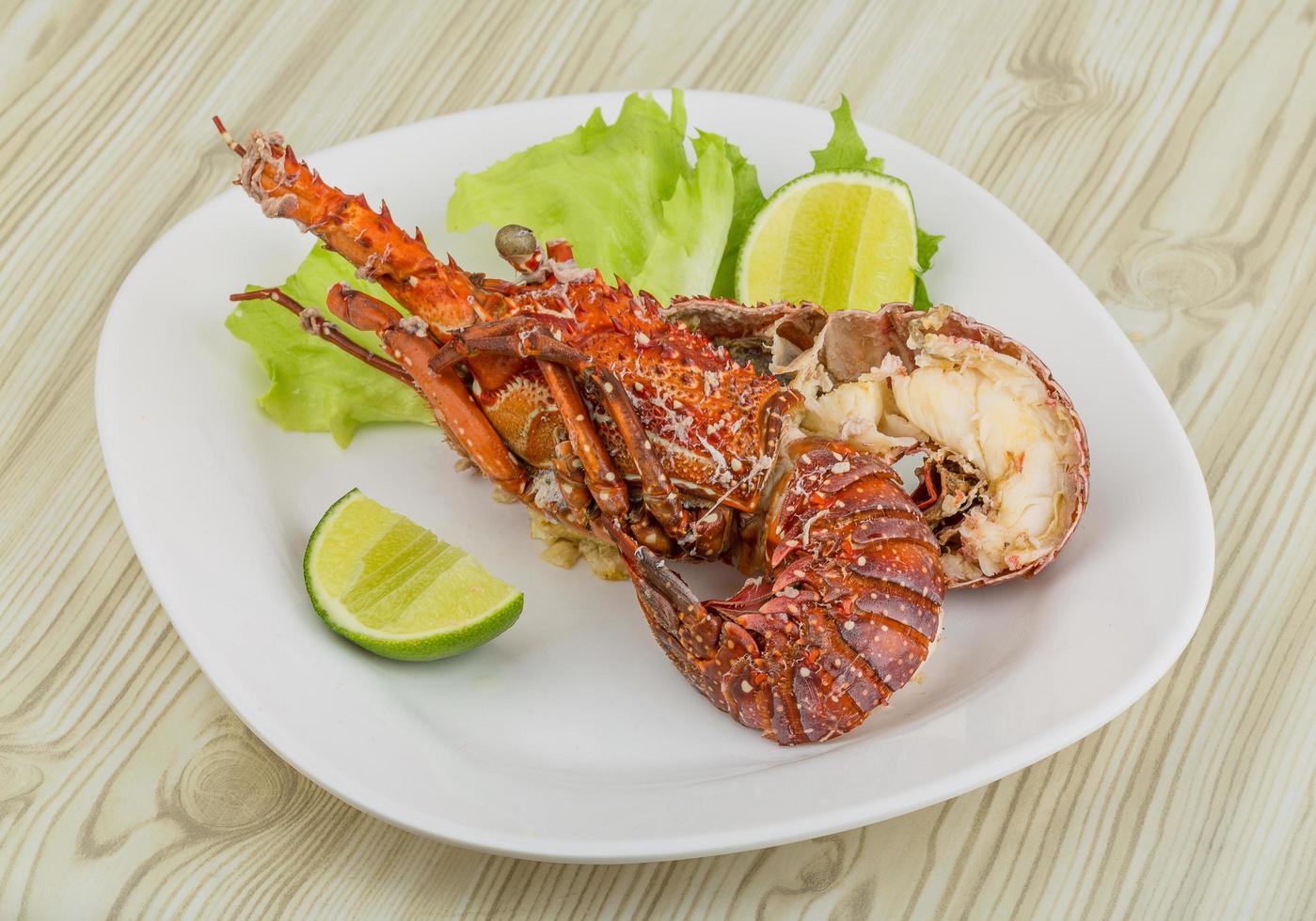 Spiny lobster on the plate and wooden background photo