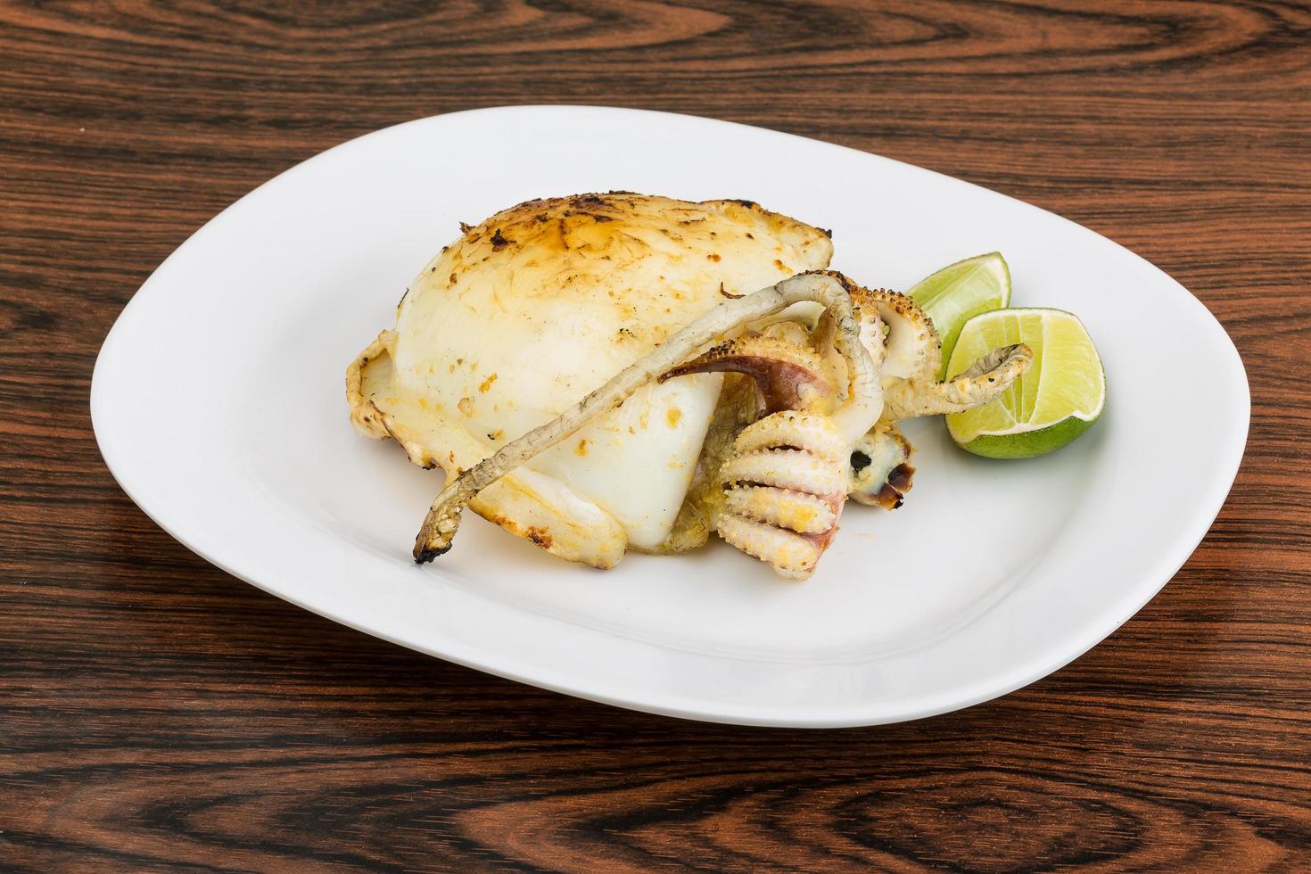 Grilled cuttlefish on the plate and wooden background