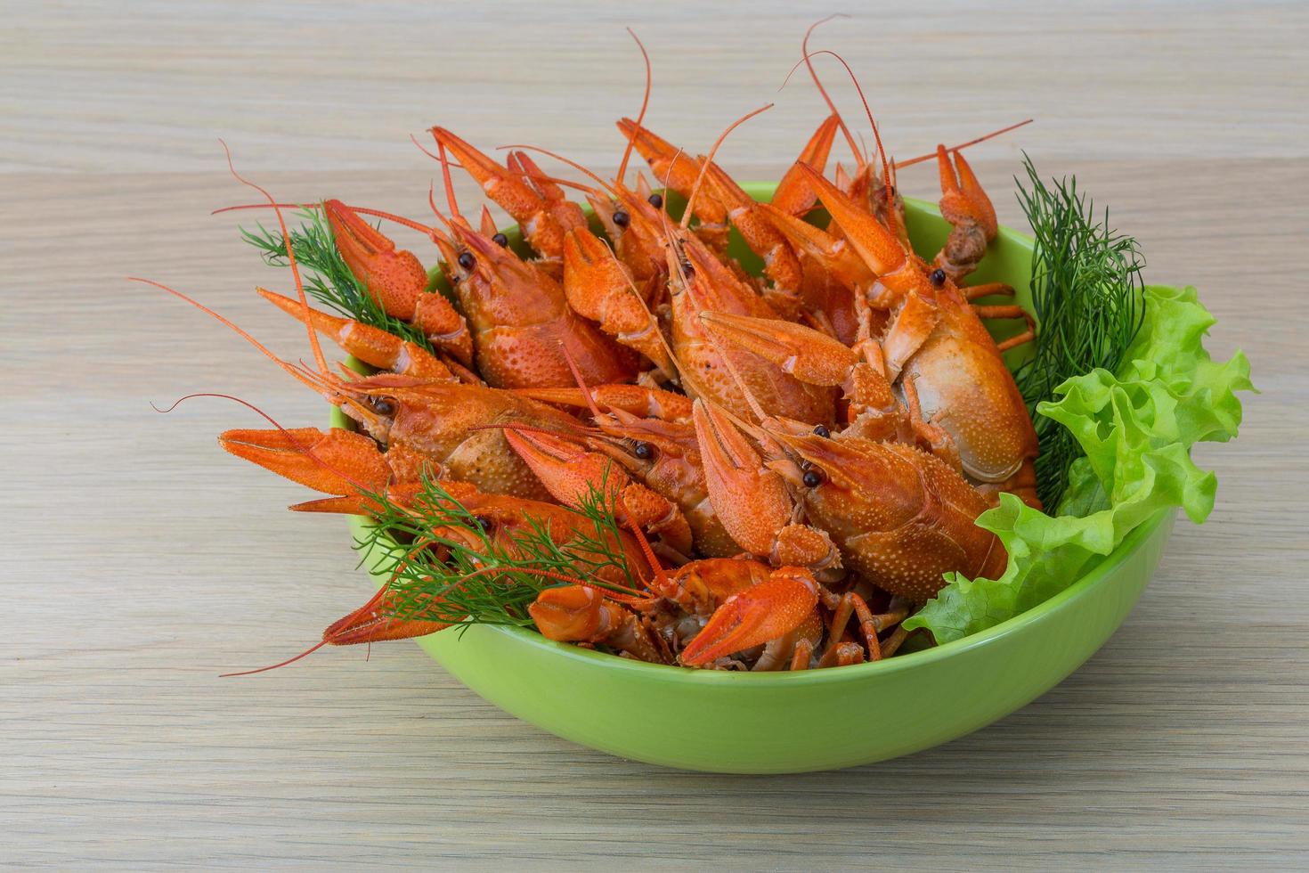 Boiled crayfish in a bowl on wooden background photo