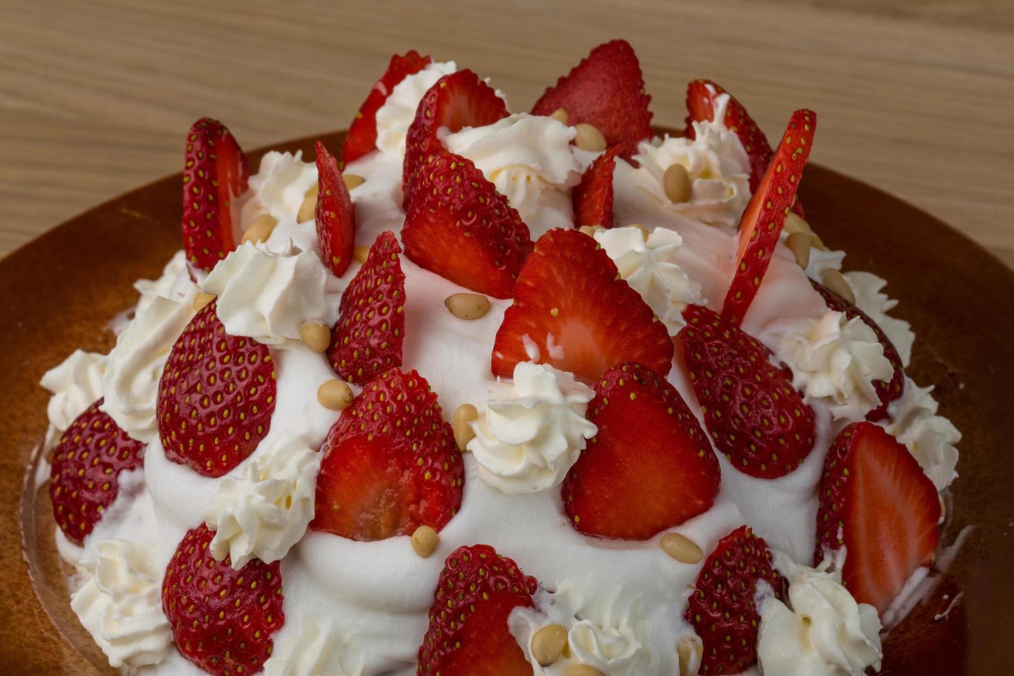 Strawberry cake on the plate and wooden background photo