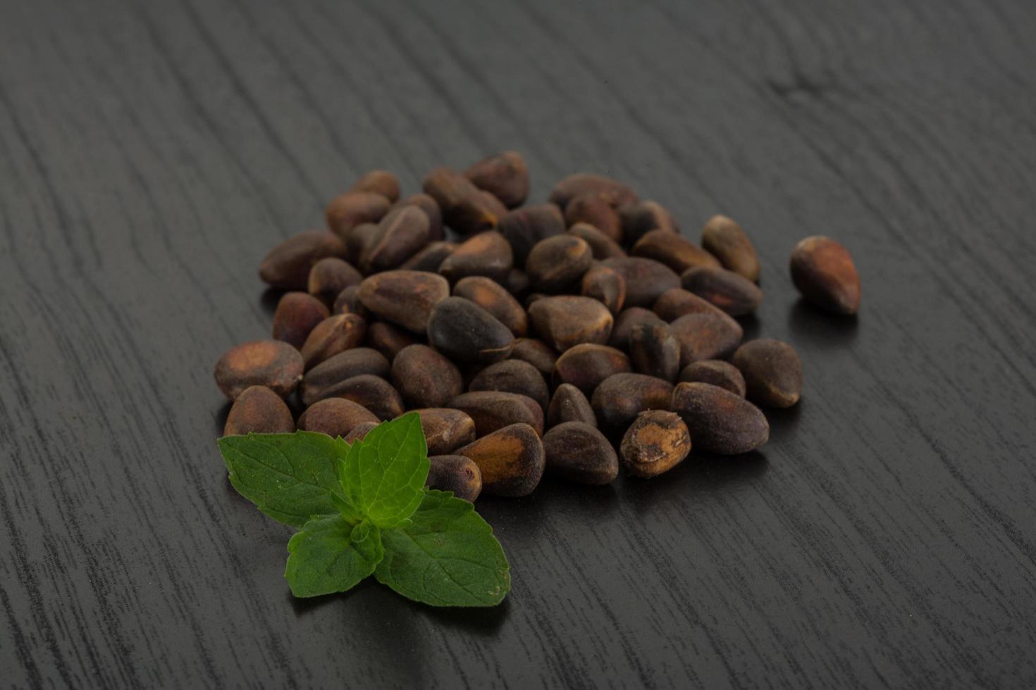 Cedar nuts on wooden background photo