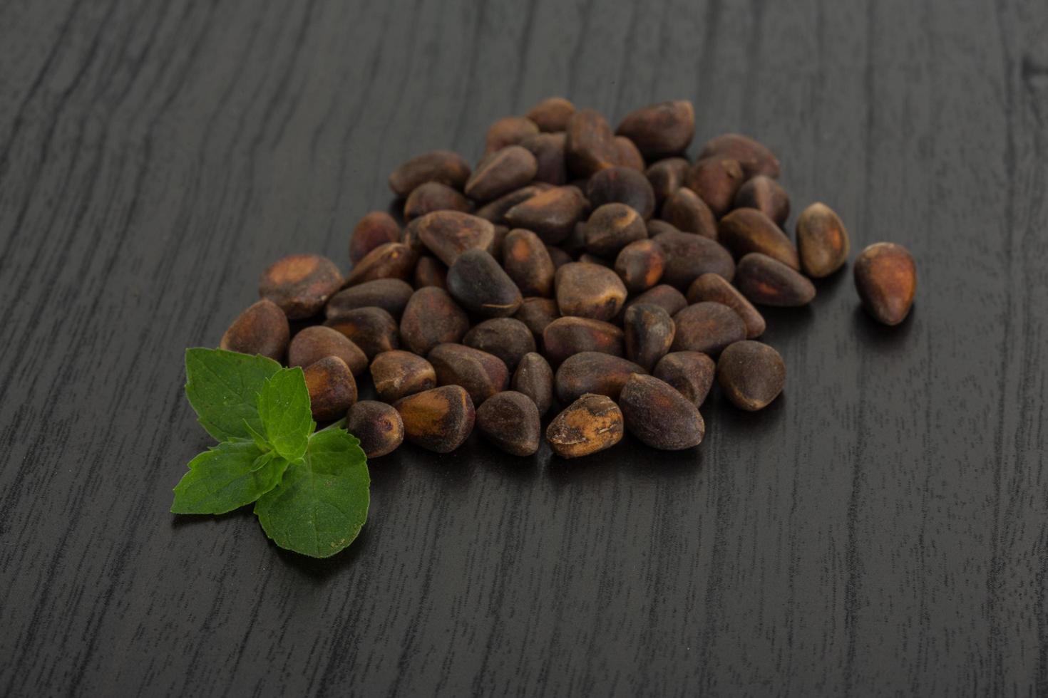 Cedar nuts on wooden background photo