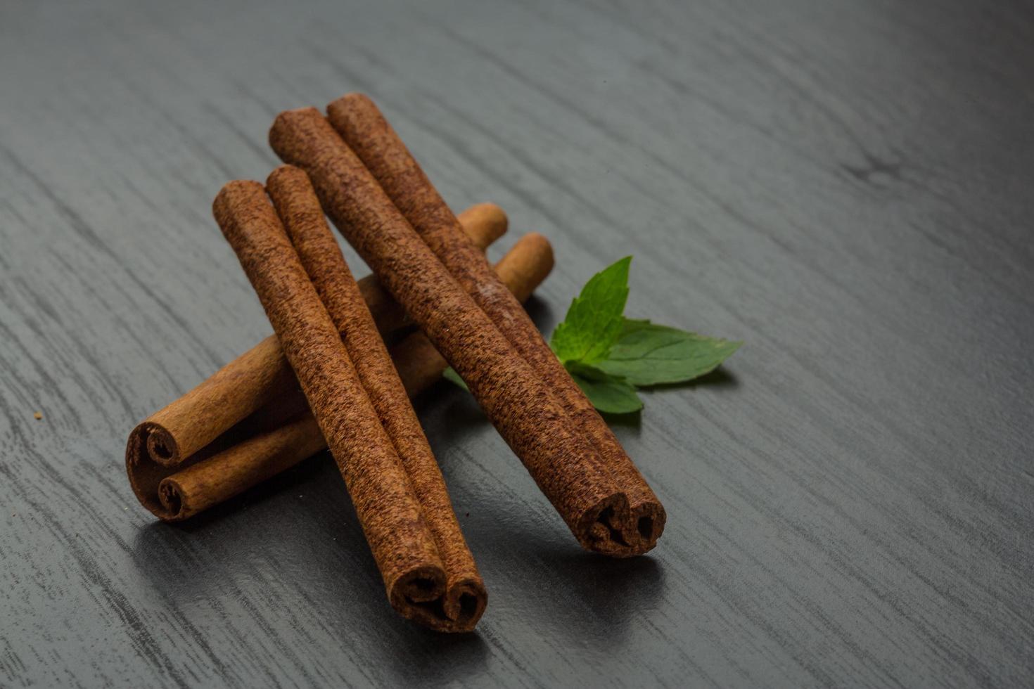 Cinnamon sticks on wooden background photo