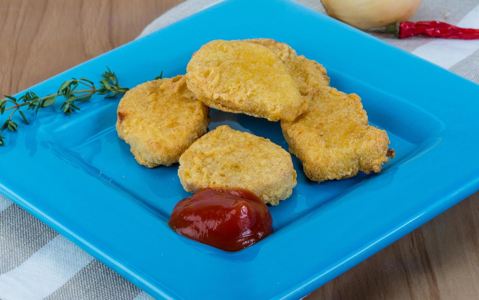 Nuggets on the plate and wooden background photo