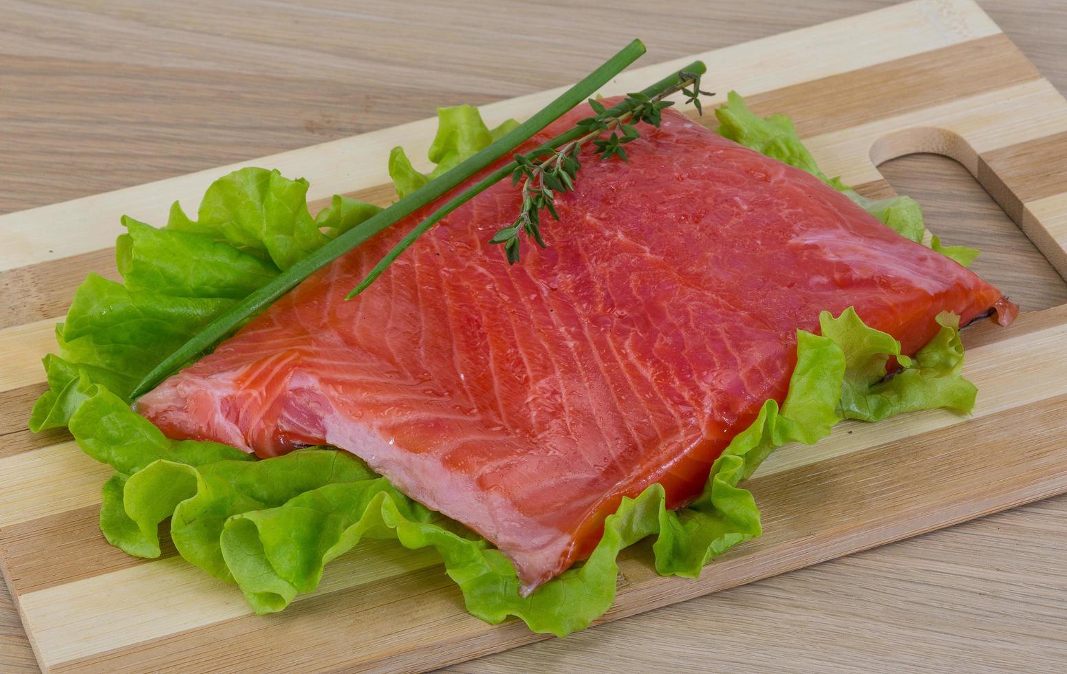 Salmon on wooden board and wooden background photo