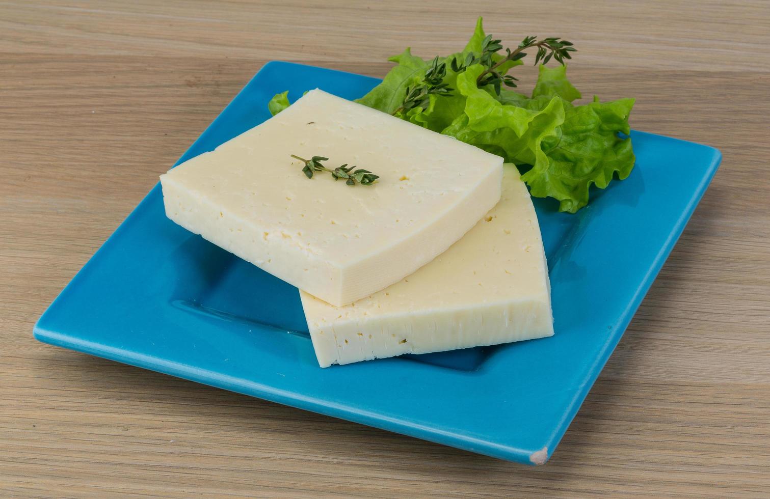 Yellow cheddar on the plate and wooden background photo
