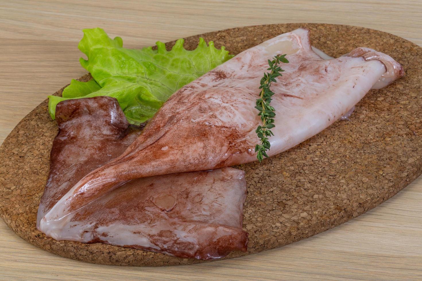 Raw squids on wooden board and wooden background photo