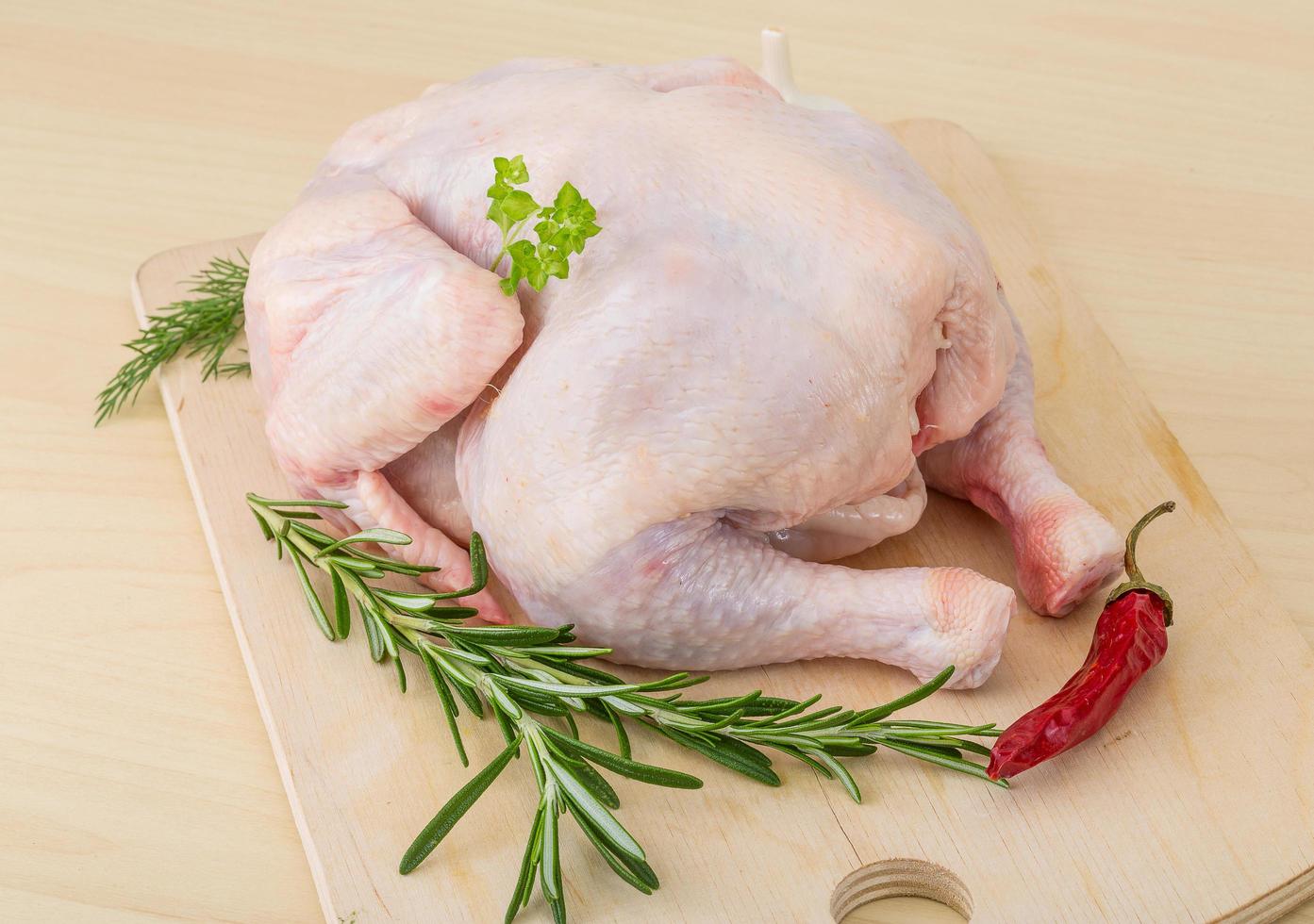 Raw chicken on wooden board and wooden background photo