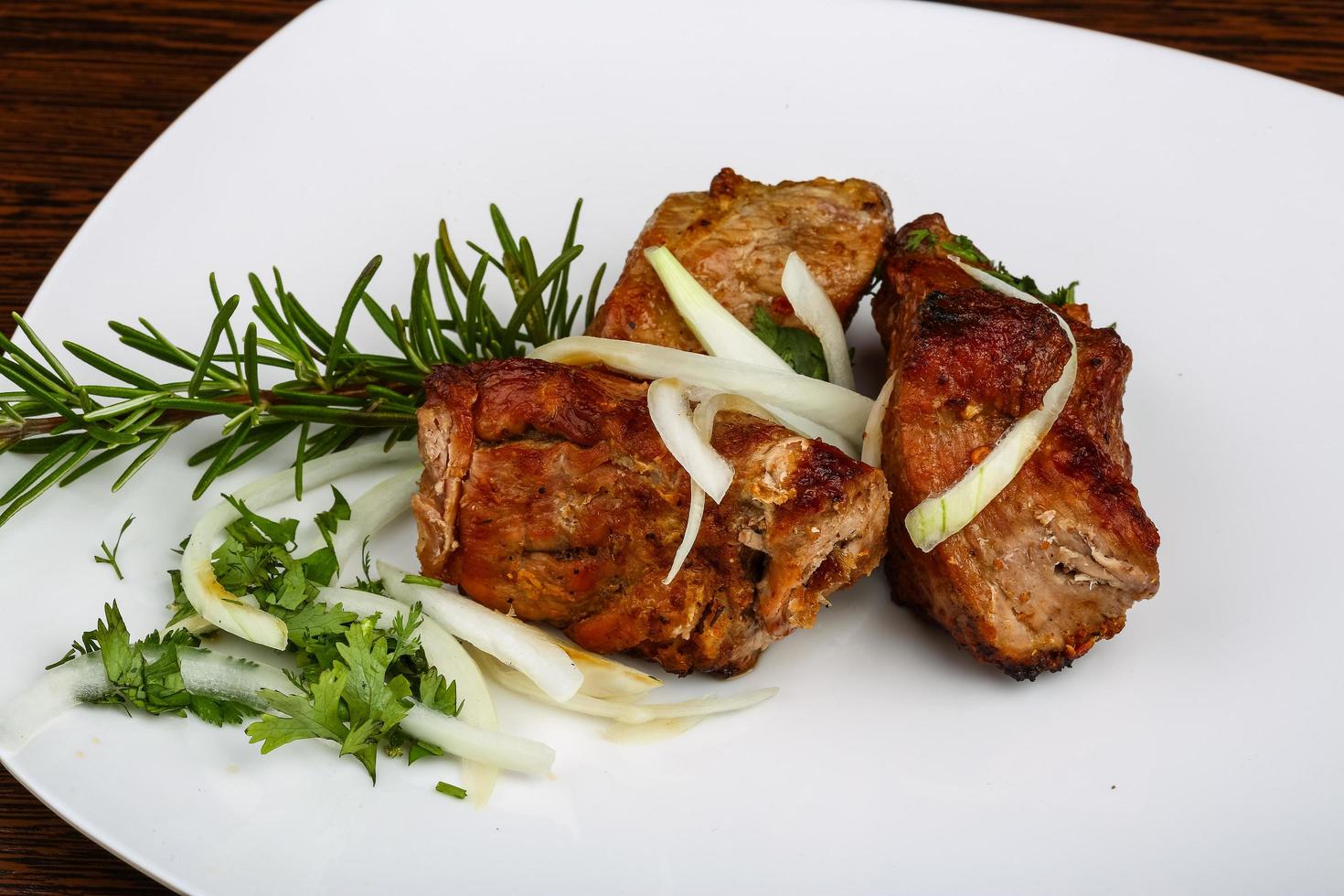Grilled pork on the plate and wooden background photo