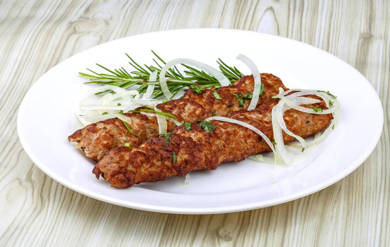 Beef kebab on the plate and wooden background photo