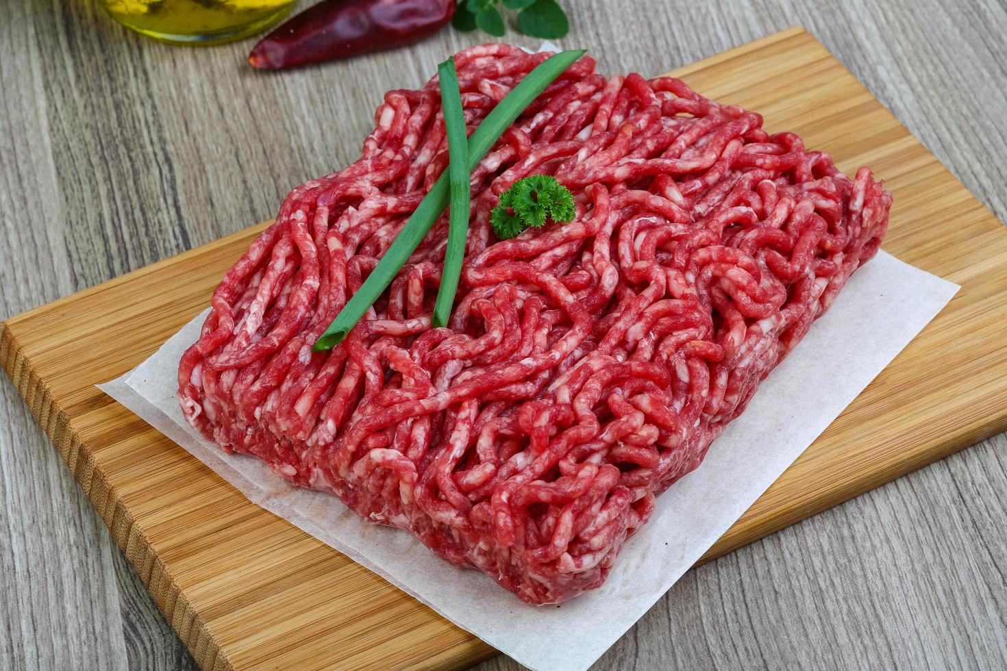 Minced beef on wooden board and wooden background photo