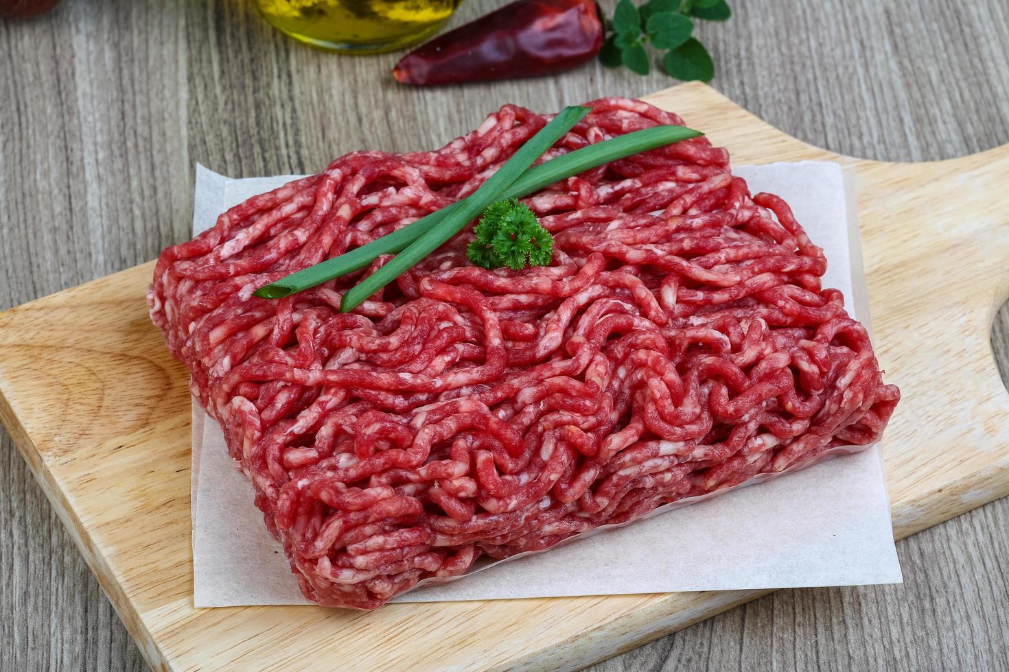 Minced beef on wooden board and wooden background photo