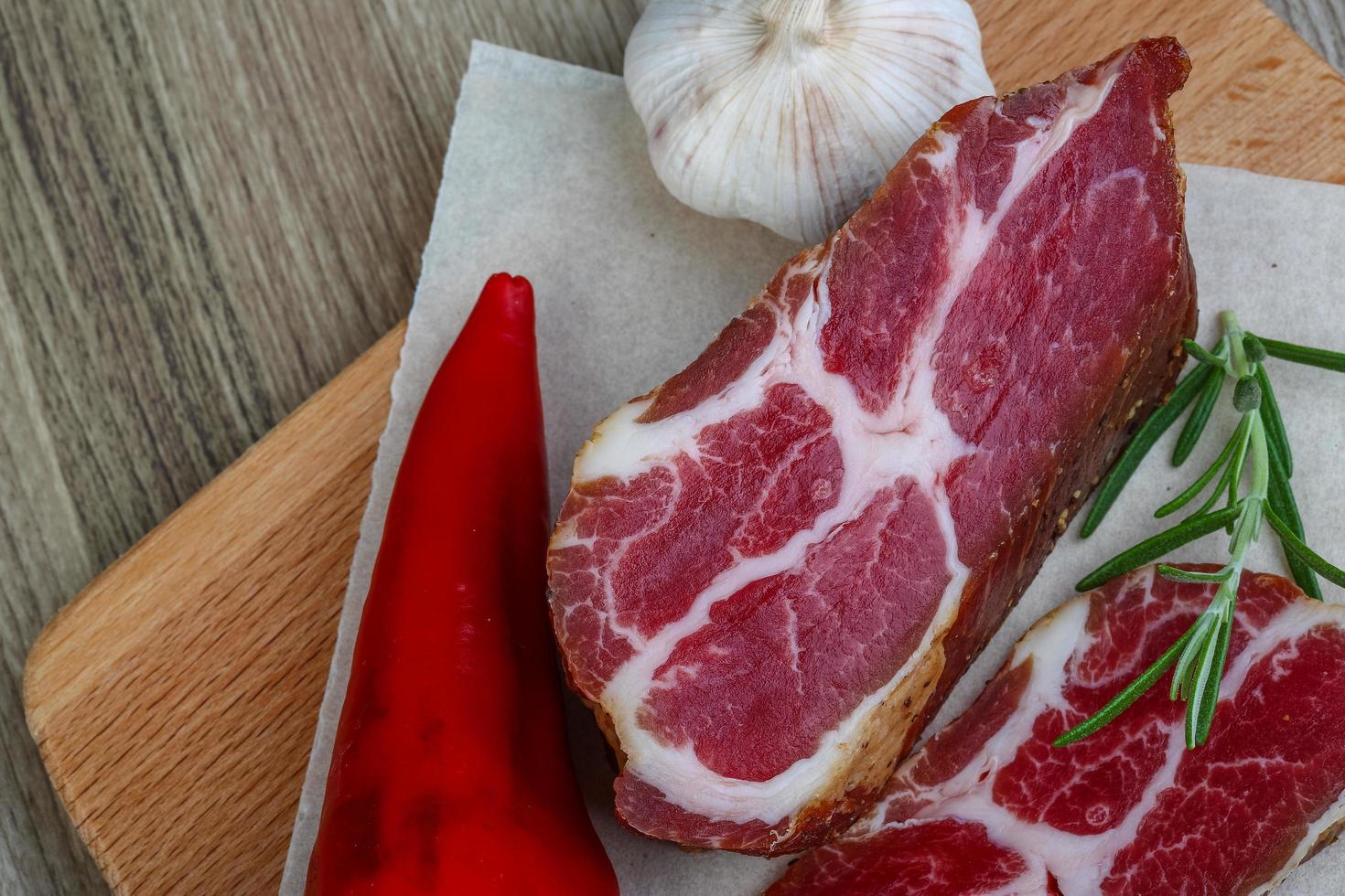 Smoked bacon on wooden board and wooden background photo