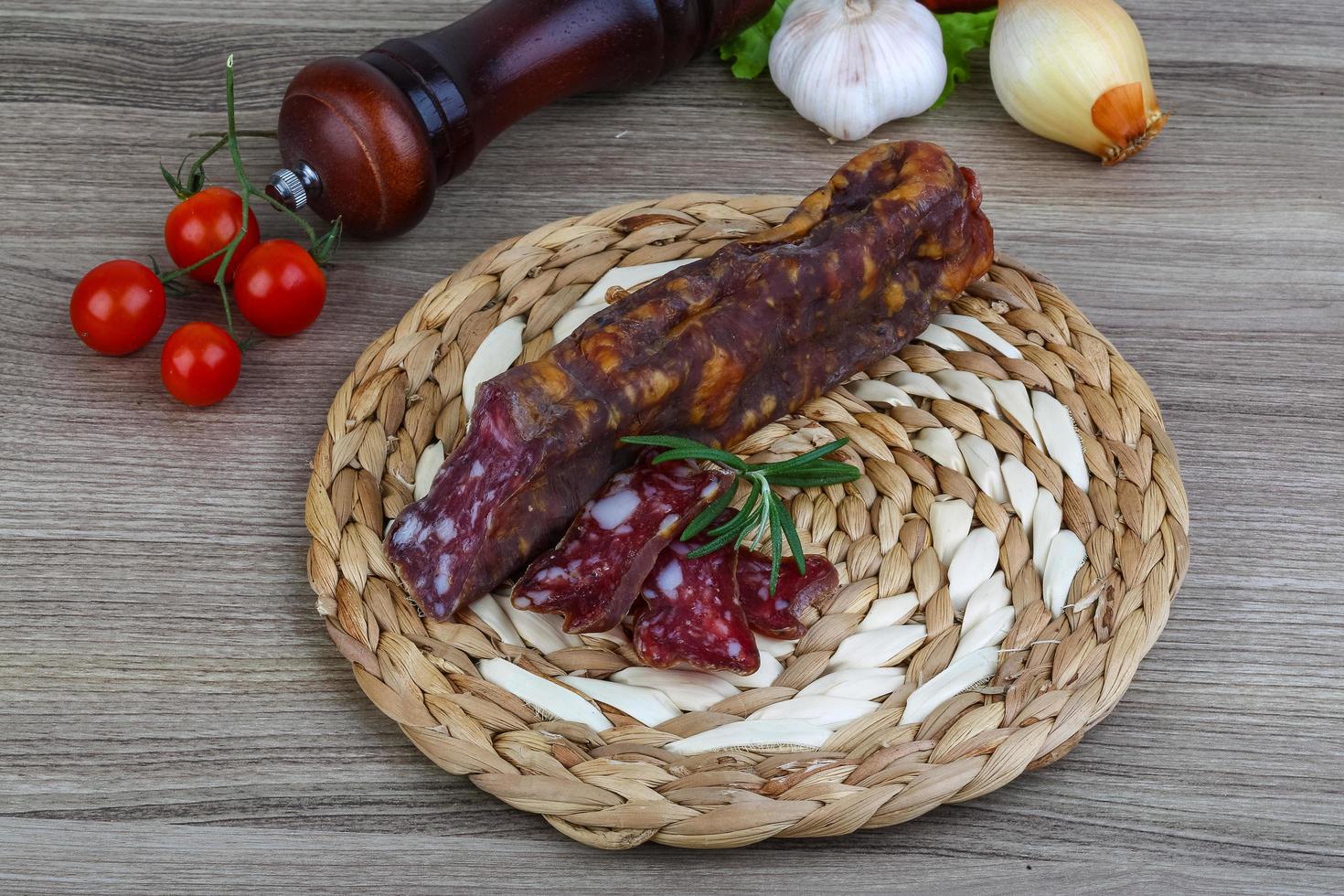 Salami sausage on wooden board and wooden background photo